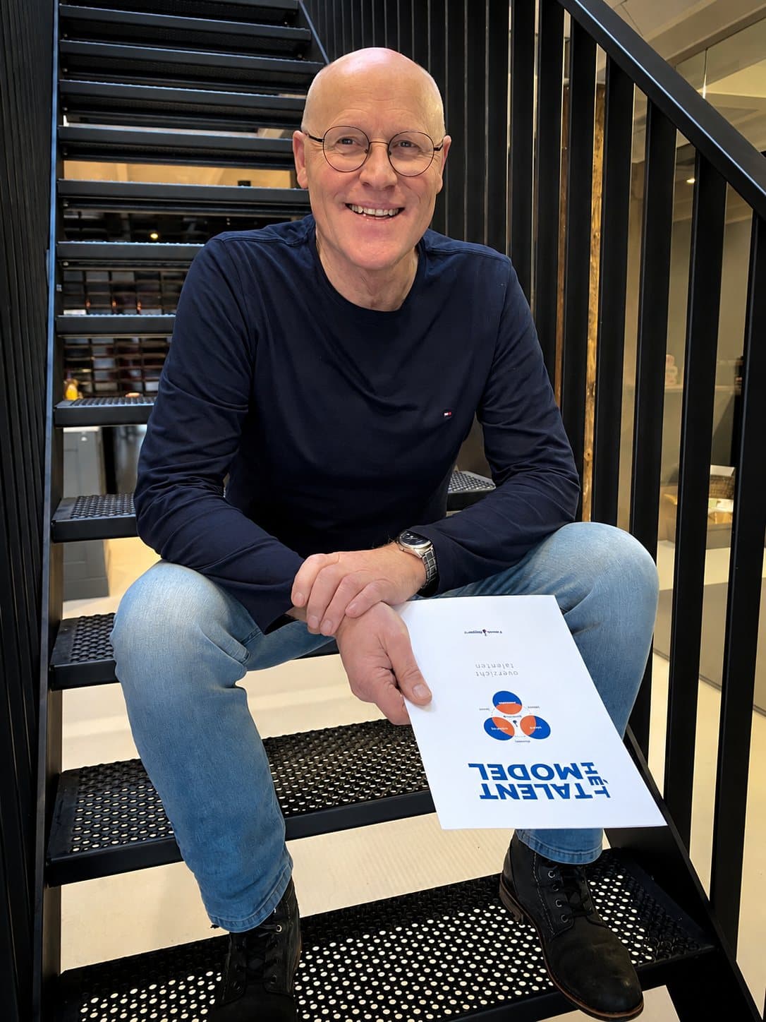 Jan Hooikammer op de trap, met het boekje van Het Talentmodel